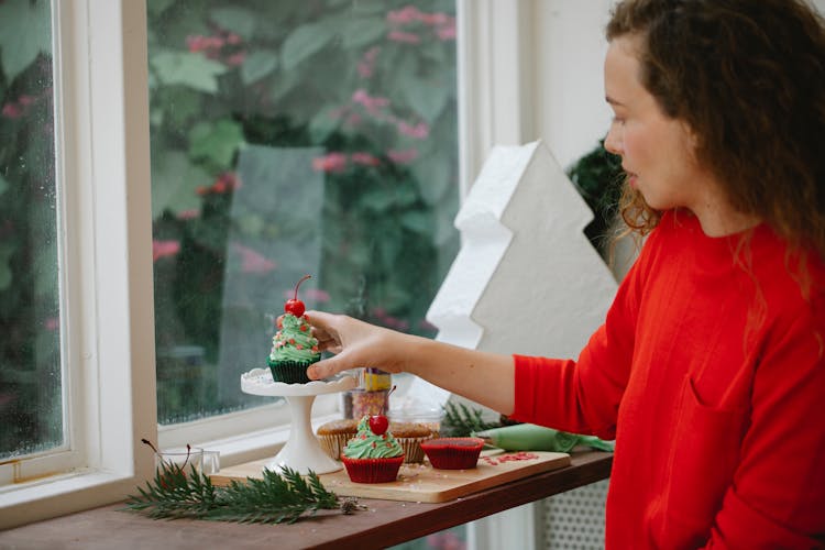 Woman Beside Window With Desserts For Christmas Party