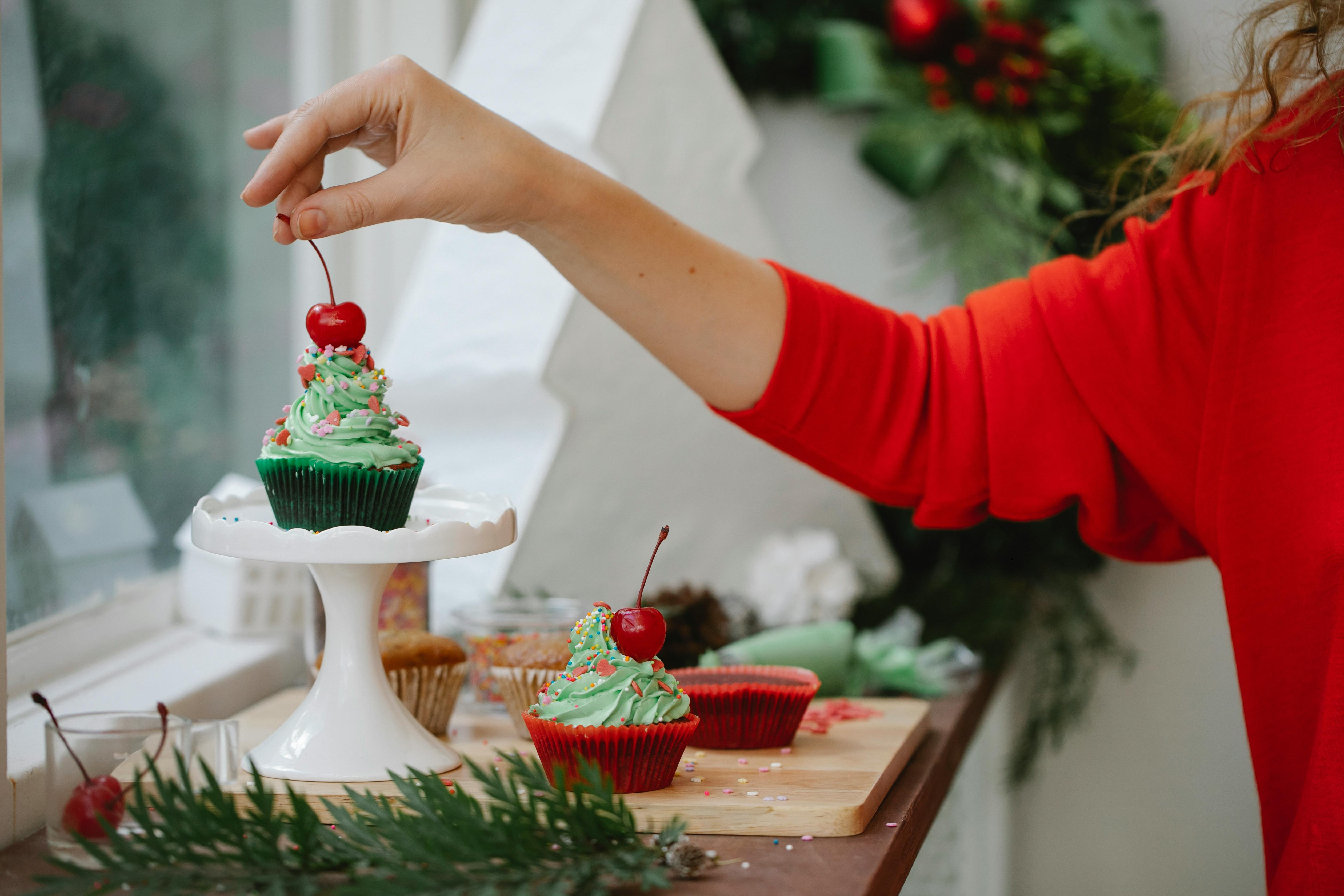 woman making christmas cupcakes with berries