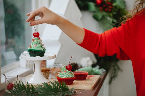 Woman making Christmas cupcakes with berries