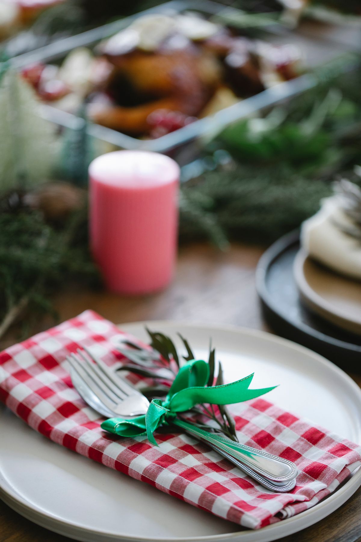 Rolled check napkin with fir sprigs in a rustic Christmas table setting