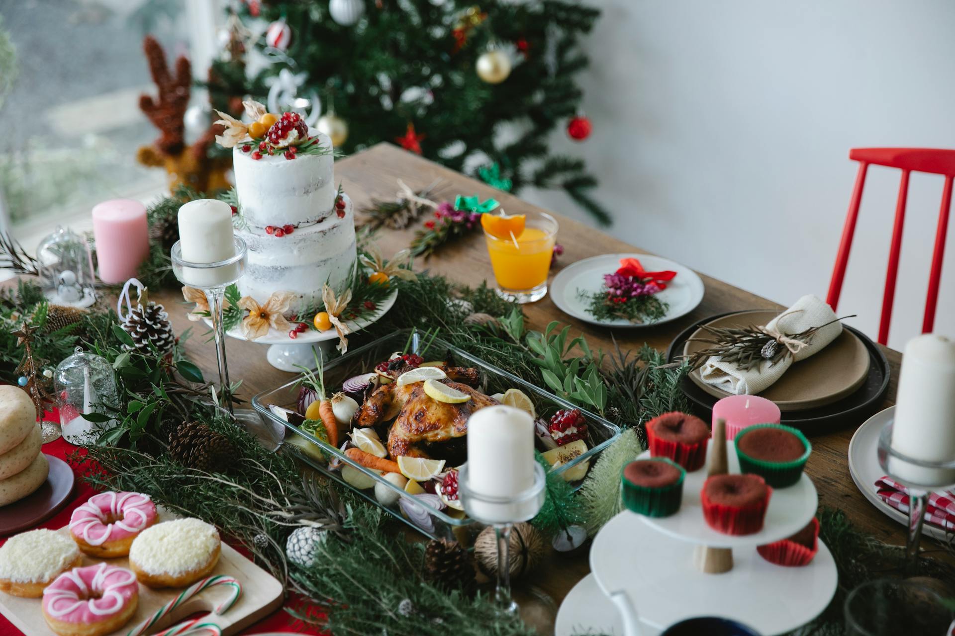 A holiday table setting with festive decorations and candles ready for Christmas dinner