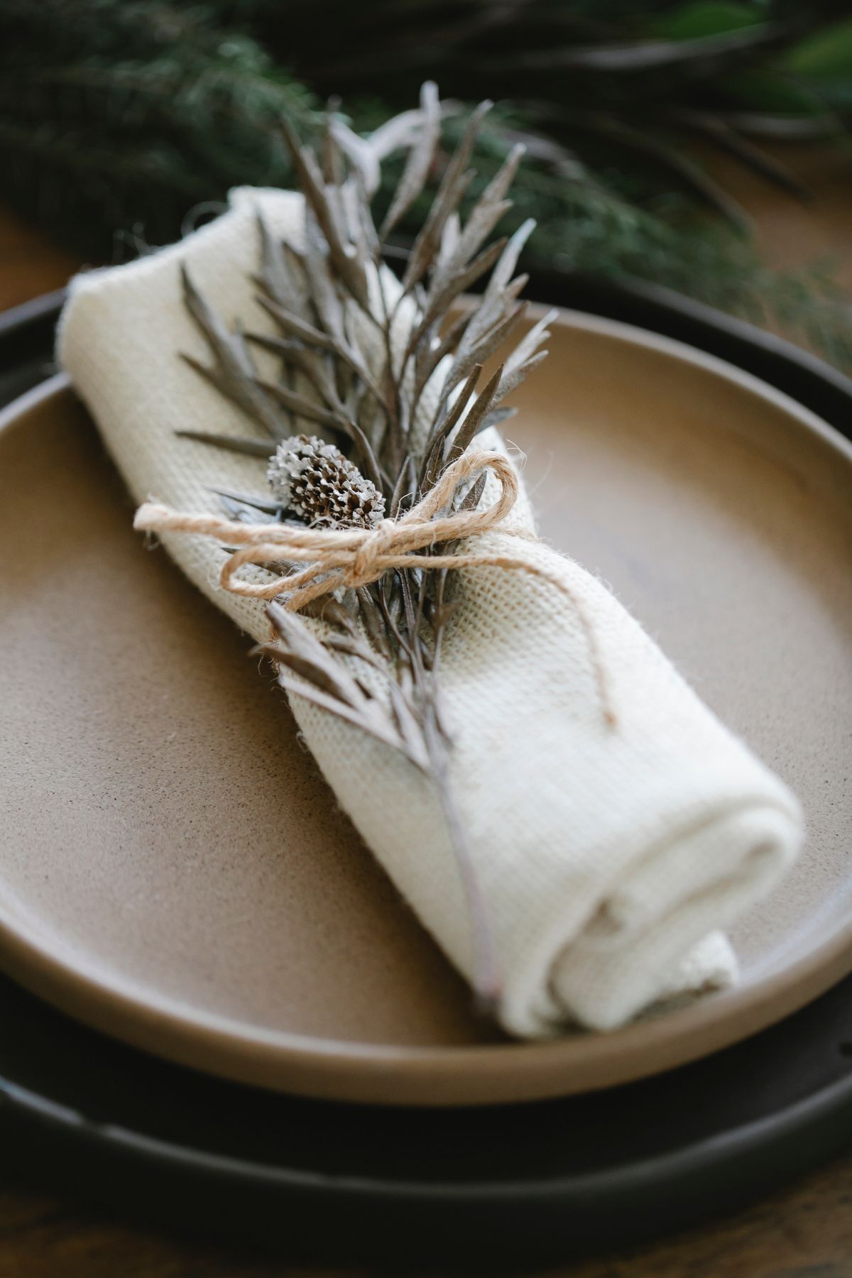 Layered waterfall napkin tied with string beside a Christmas plate