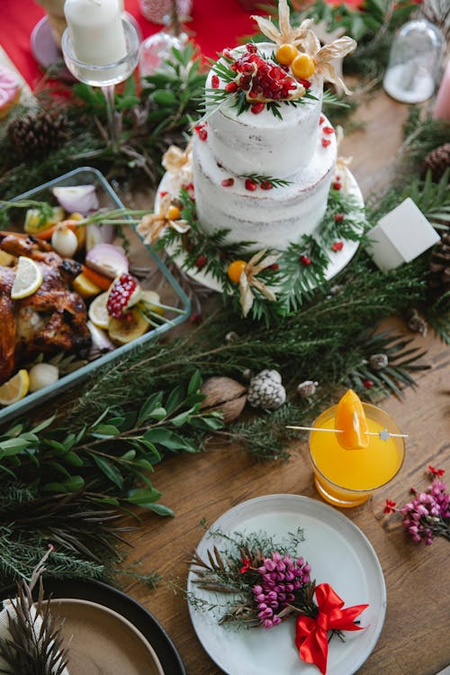 Christmas table with cake with leaves and berries near drink