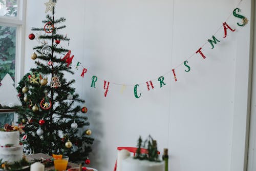 Free Christmas tree with decorations in room near table Stock Photo