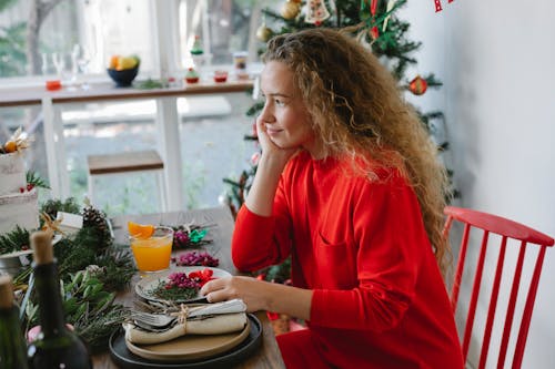 Dreamy woman at table with decor during New Year holiday