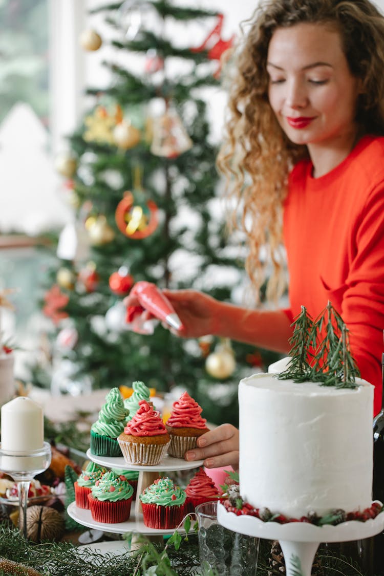 Crop Smiling Chef Decorating Delicious Cupcakes On Christmas Day Indoors