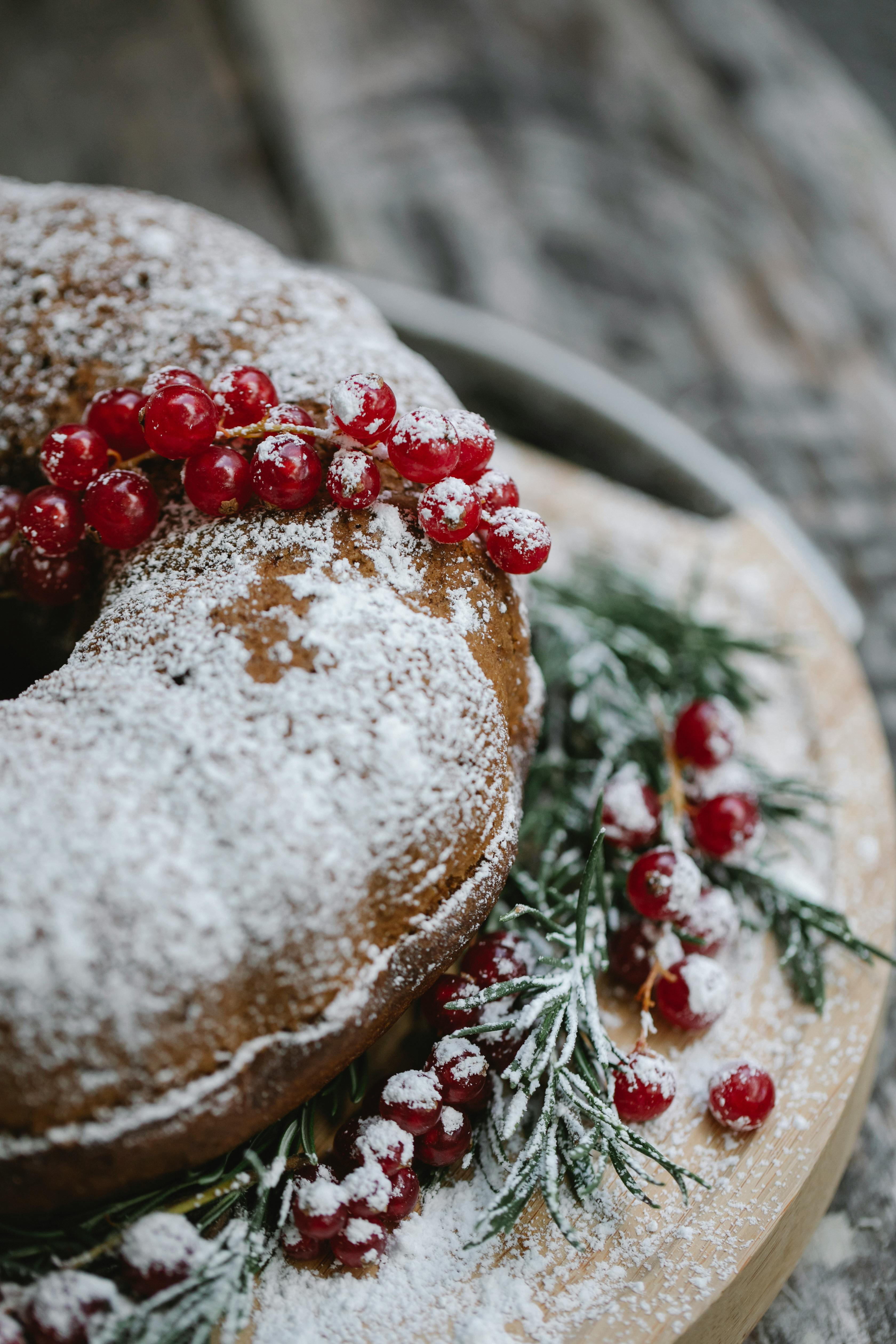 delicious cake with red berries and fir sprigs on tray