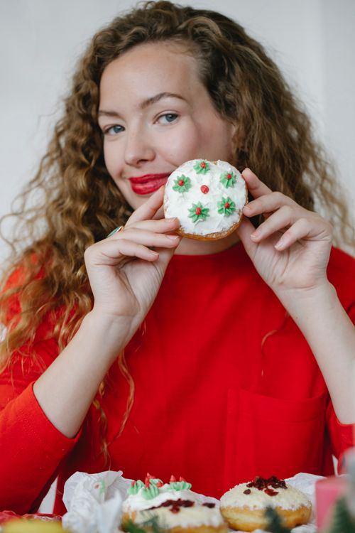Free Content adult female with red lips and yummy doughnut with buttercream looking at camera during New Year holiday Stock Photo