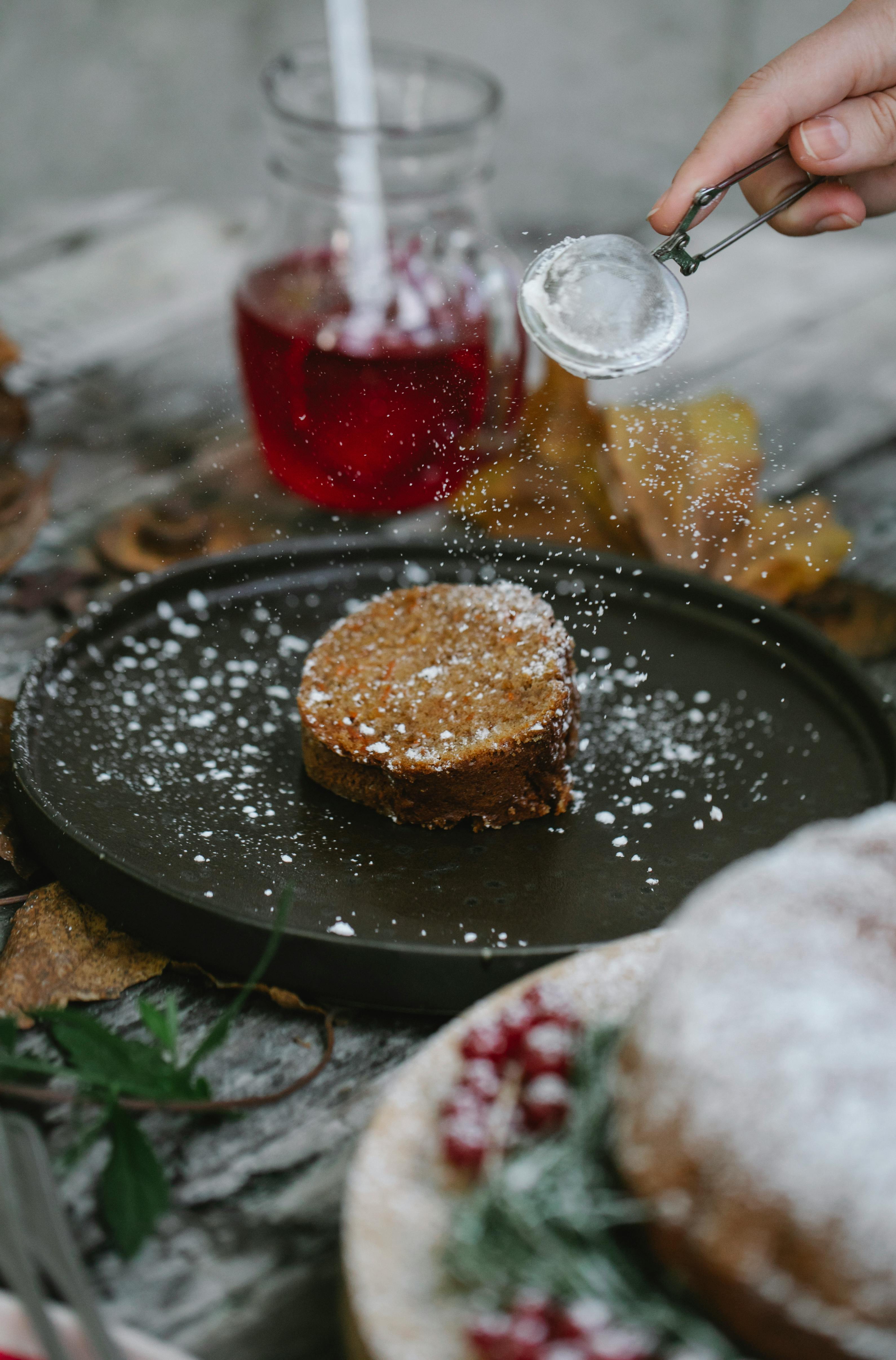 crop unrecognizable chef garnishing pie slice with sugar powder