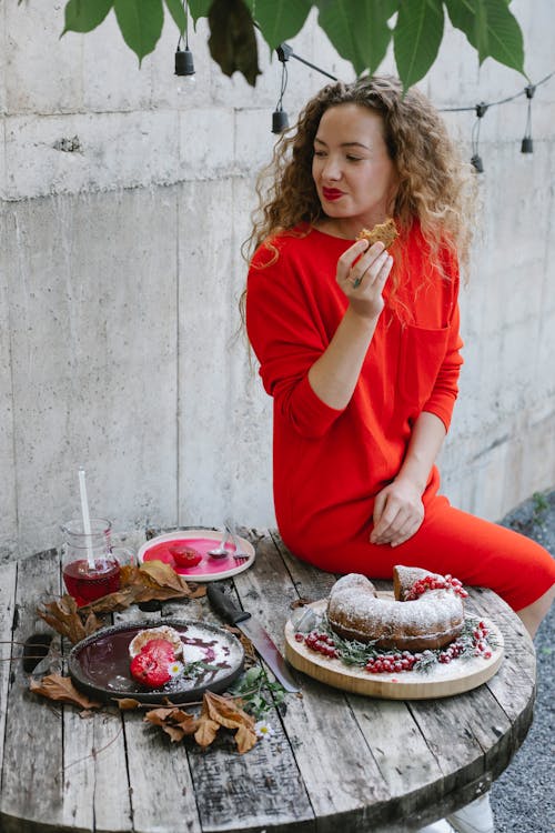 Happy young woman eating delicious pie on backyard