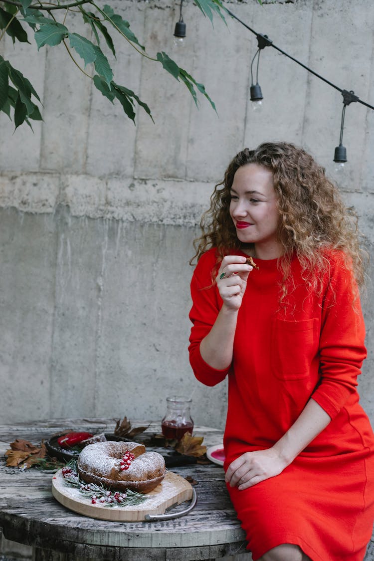 Smiling Woman Eating Tasty Pie In Garden