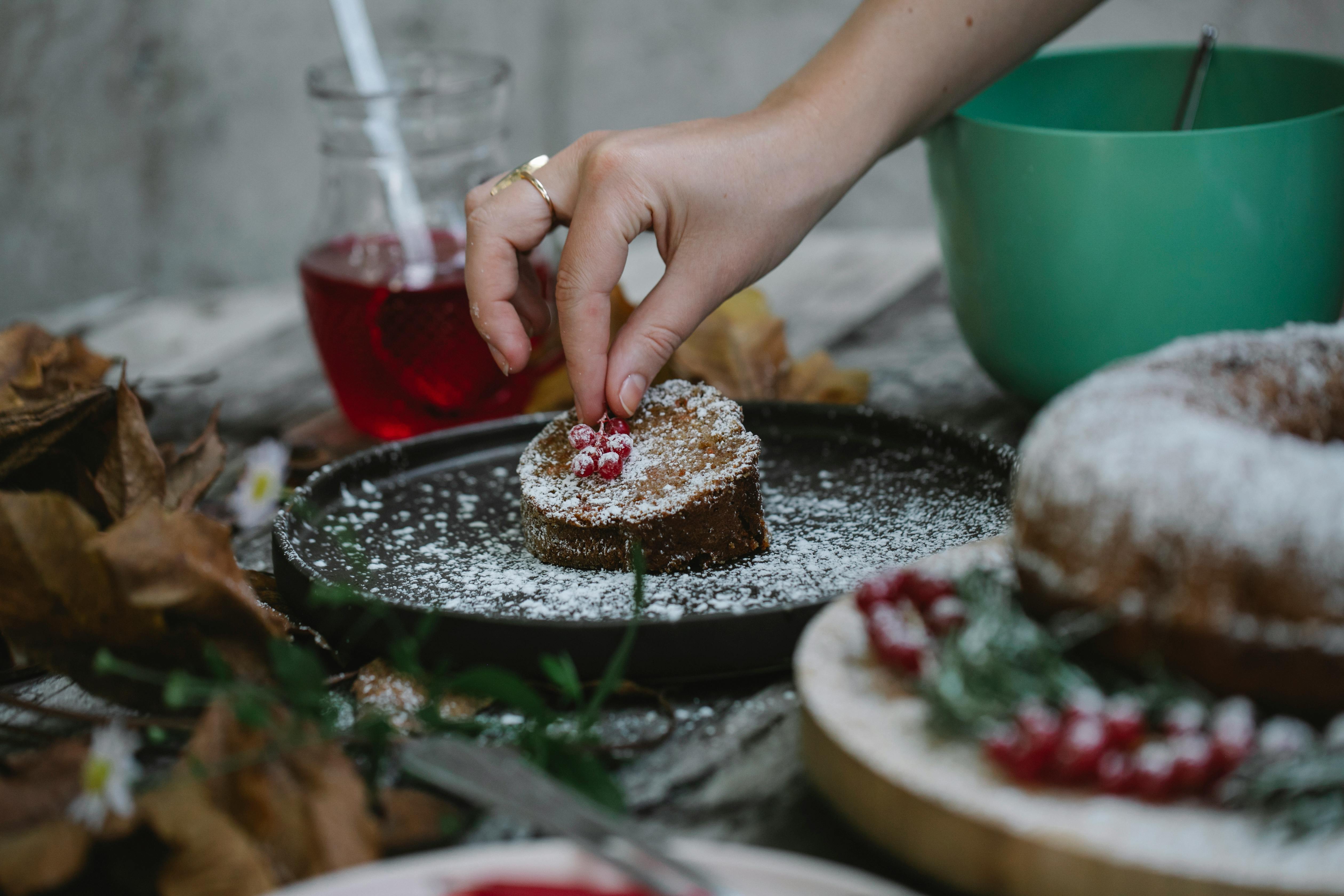 crop faceless housewife decorating pie slice with red currant