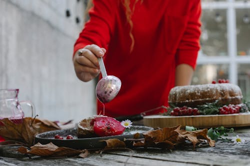 Woman decorating dessert with sweet syrup