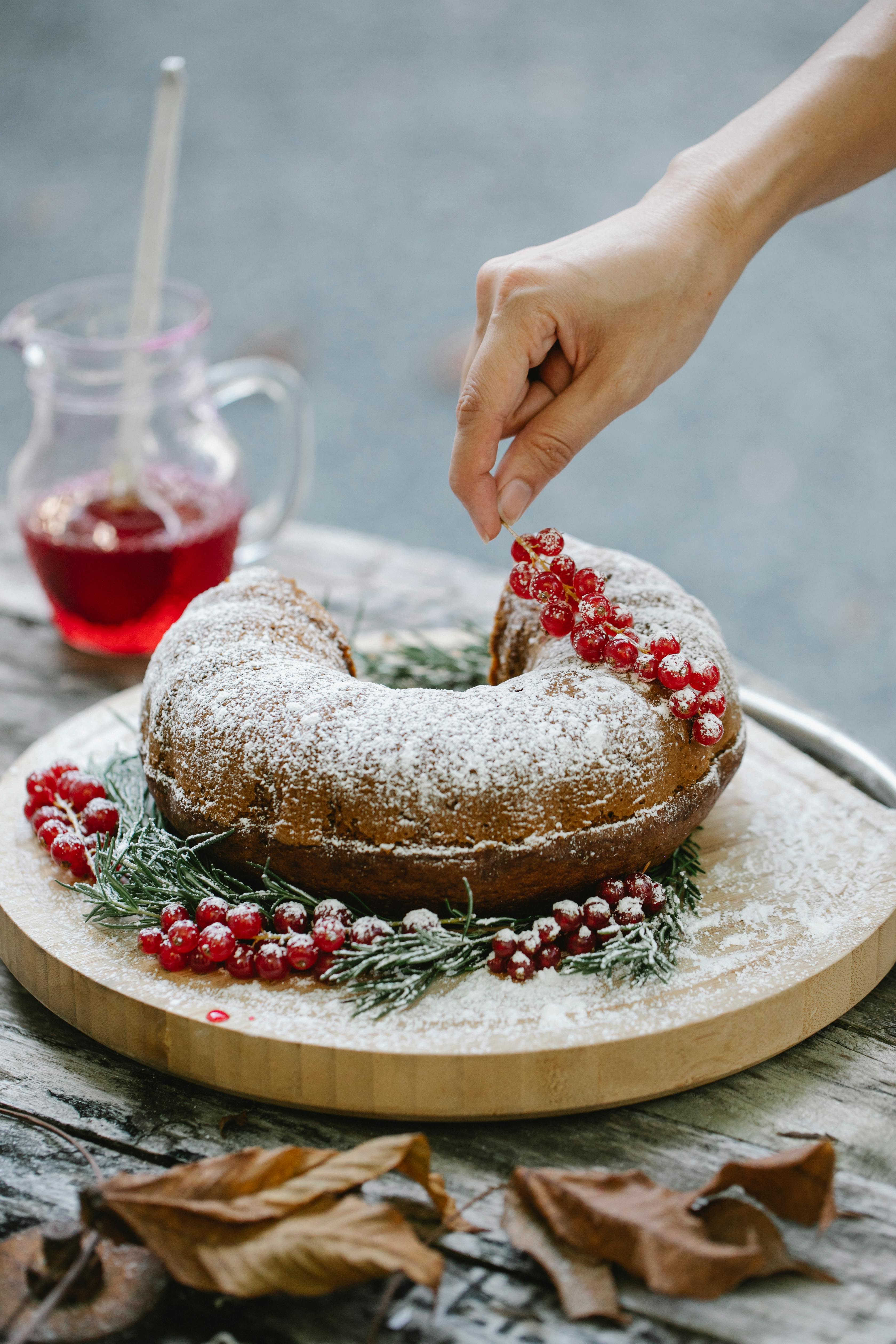 woman decorating christmas cake with redcurrant