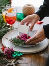 Crop man arranging decorative flowers on plate
