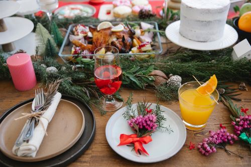Free From above of festive table full of various food and served plates with natural decorations near candles and glasses of alcohol drinks Stock Photo