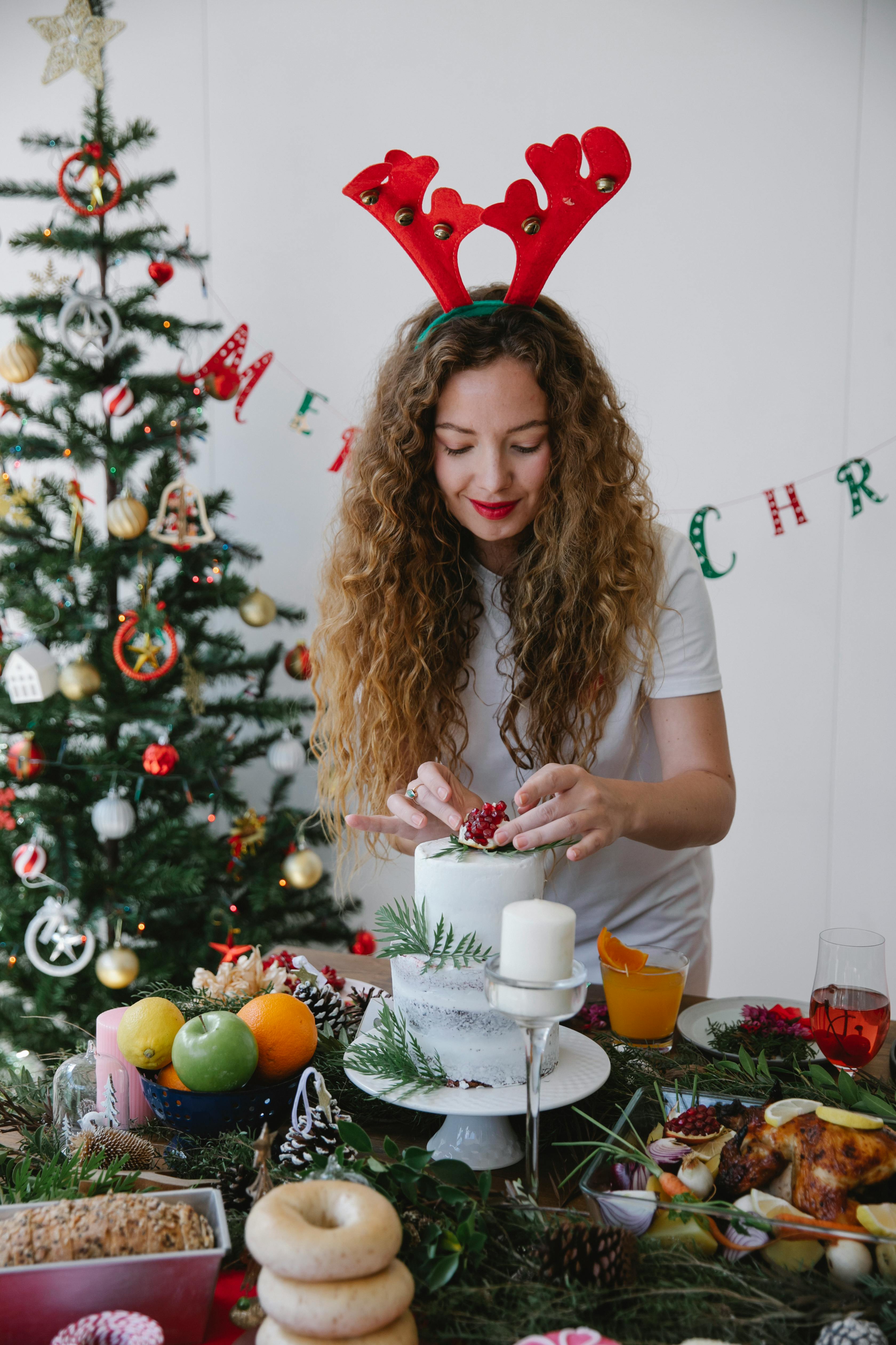 woman in reindeer hat preparing dessert at christmas table