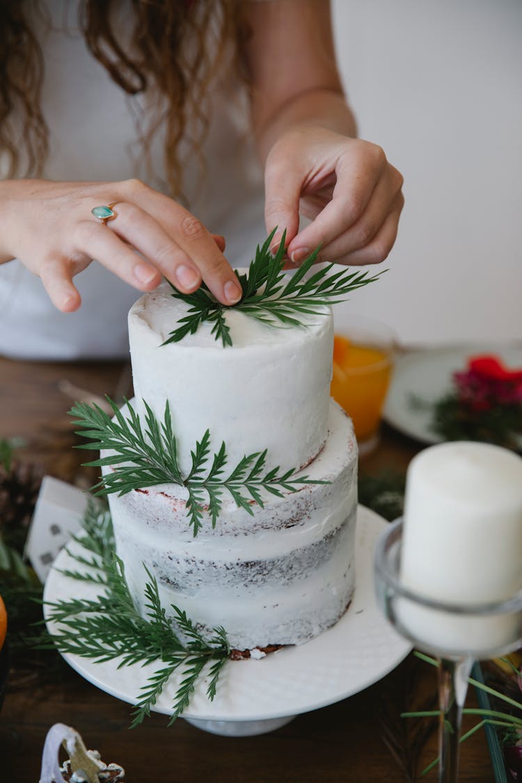 Crop Woman Decorating Cake With Herbs