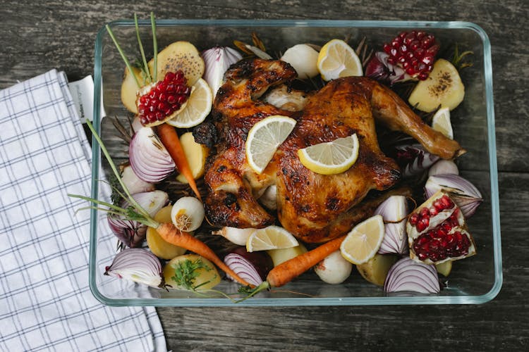 Delicious Roasted Chicken With Assorted Vegetables And Fruits On Table