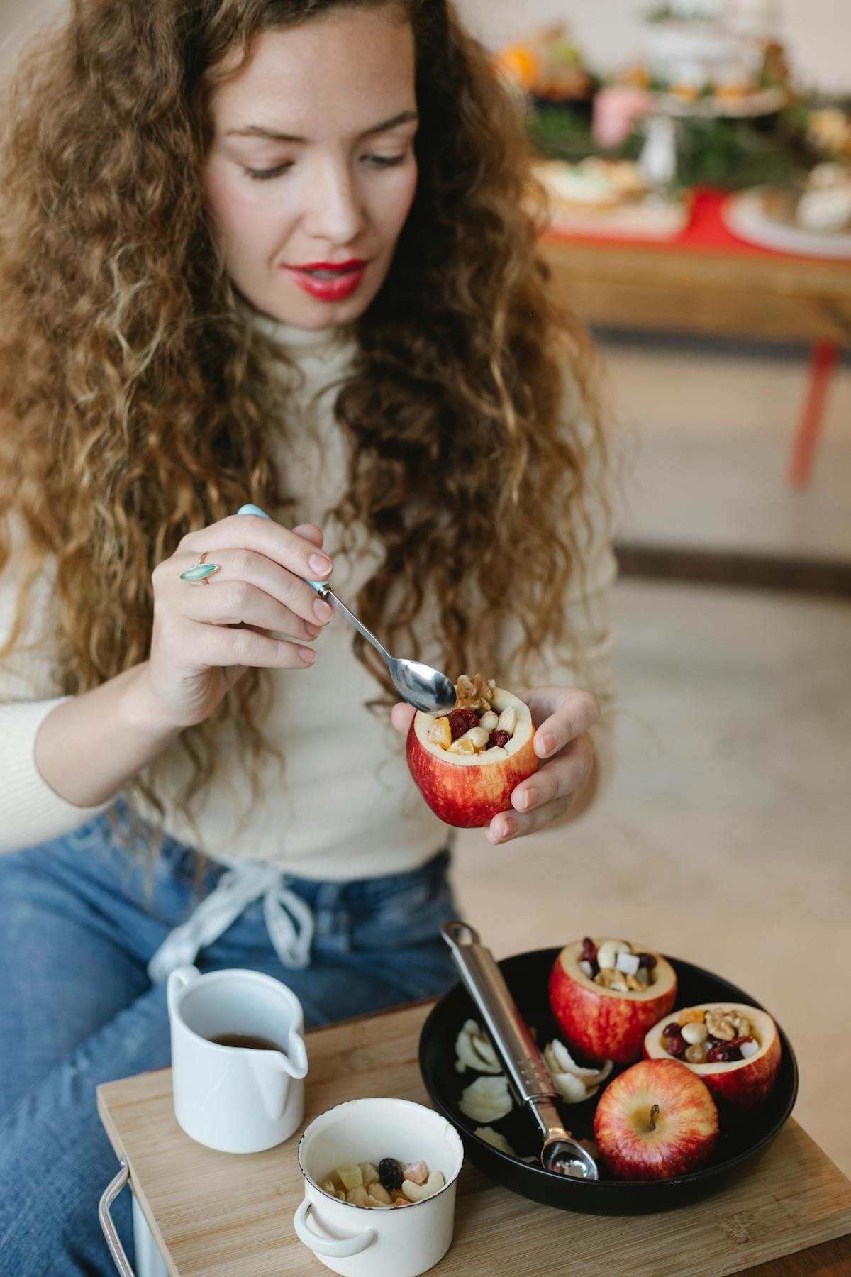 Person preparing a colorful bowl with vegetables and grains on a wooden table