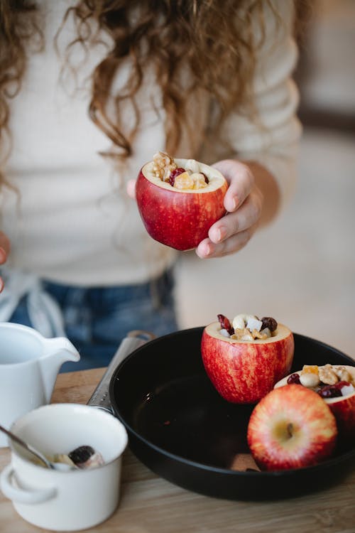 Faceless cook preparing stuffed apples at home