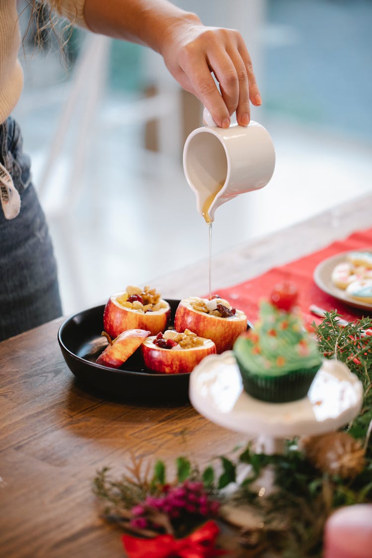 Crop Cook Pouring Honey On Filled Apple During Christmas Holiday