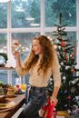 Amazed woman with champagne celebrating Christmas holiday at home