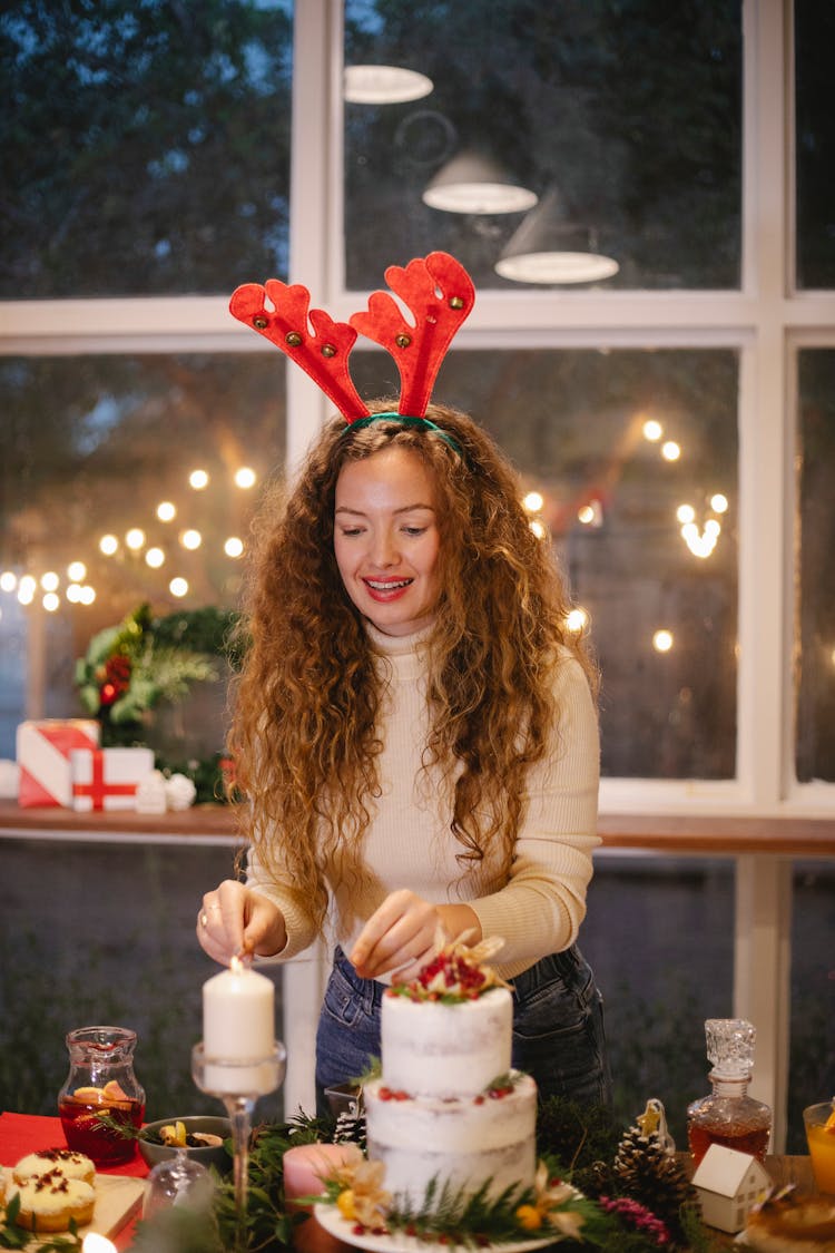 Content Woman With Burning Candle During Christmas Holiday In House