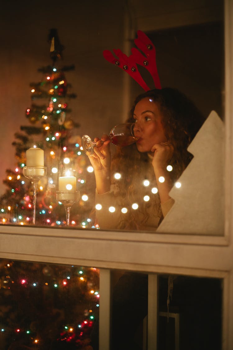 Dreamy Woman Drinking Champagne During Christmas Holiday At Home