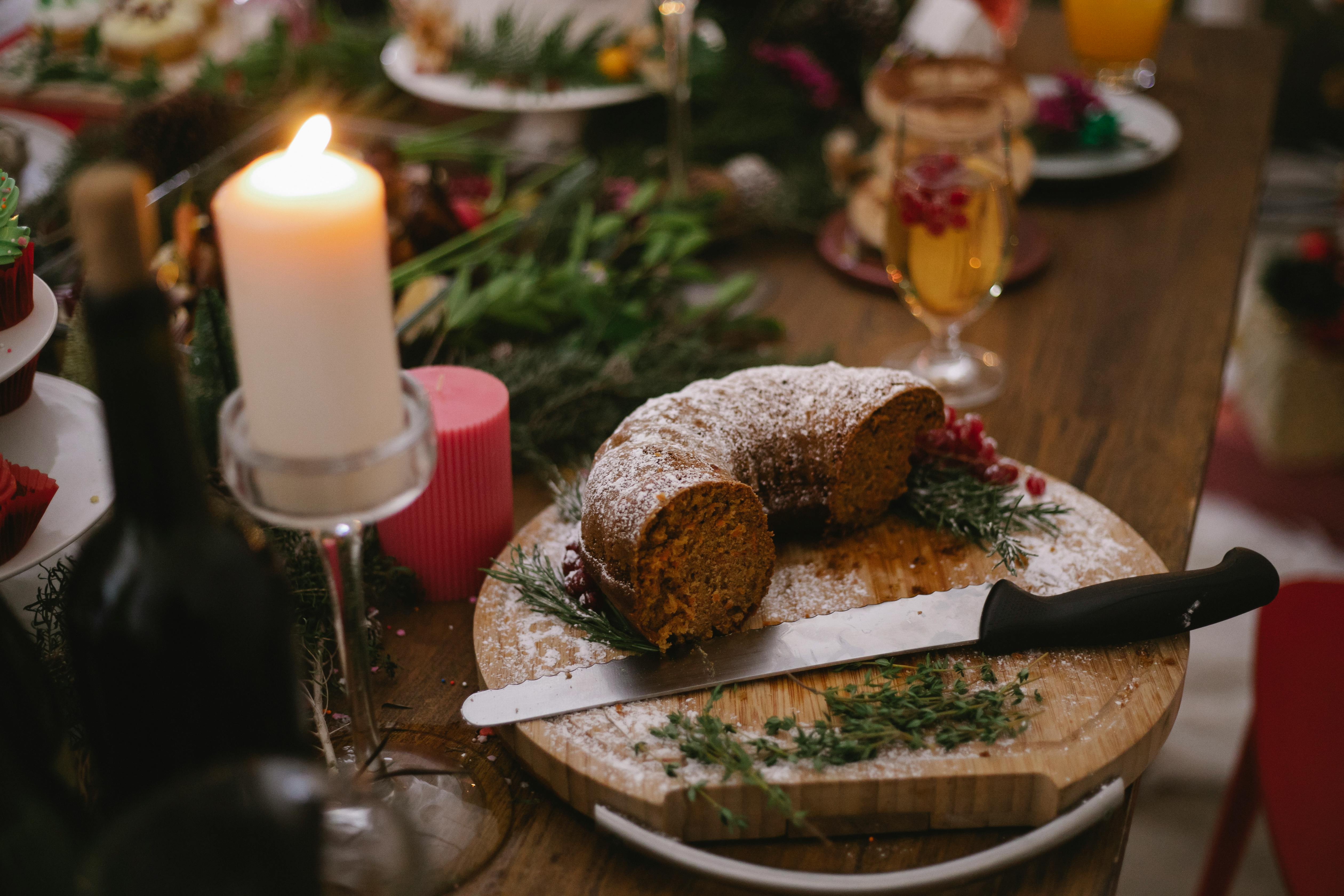 burning candle near tasty chocolate cake on table