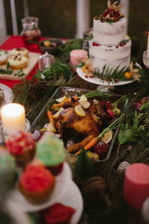 Free From above of delicious roasted chicken with vegetables against decorated cake during festive event in house Stock Photo