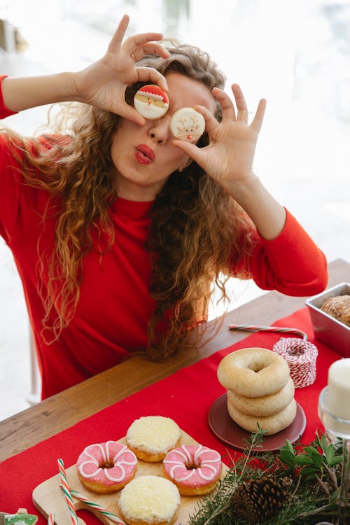 женщина в красной рубашке с длинным рукавом с бело коричневым пончиком