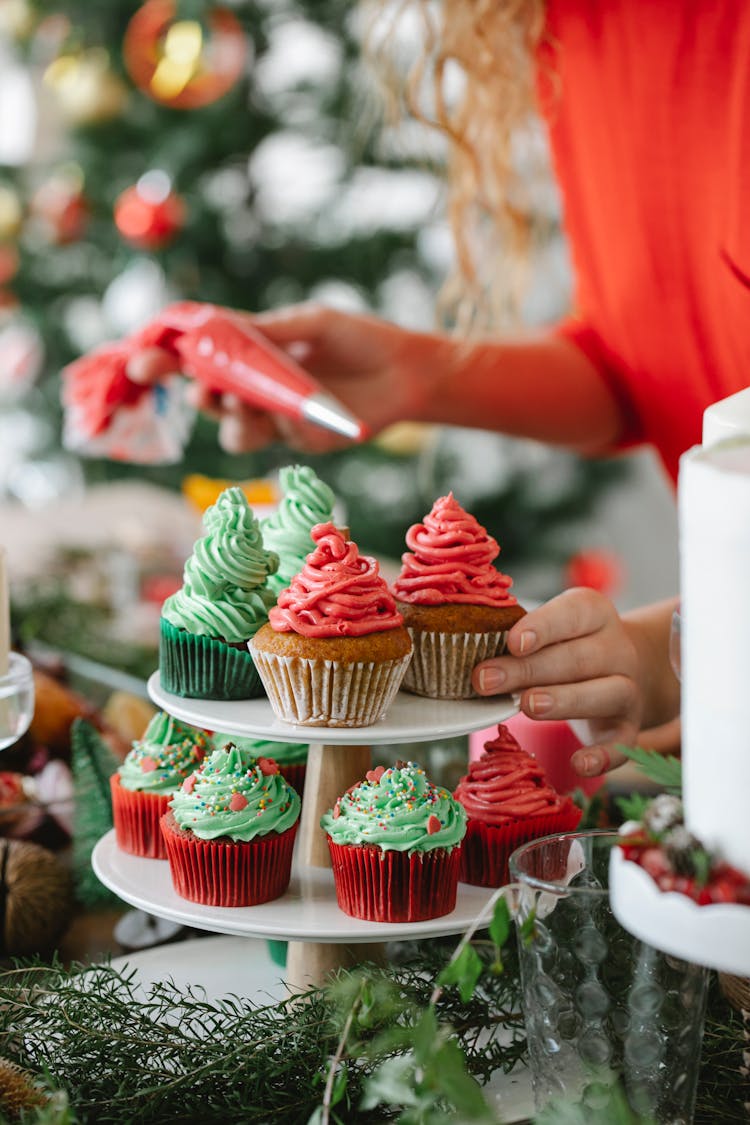 Woman Decorating Cupcakes With Cream For Christmas Holiday