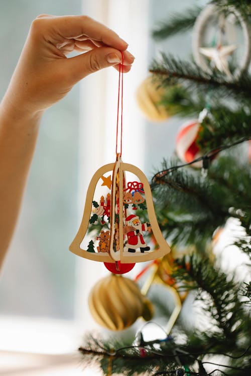 Woman decorating fir tree with toy