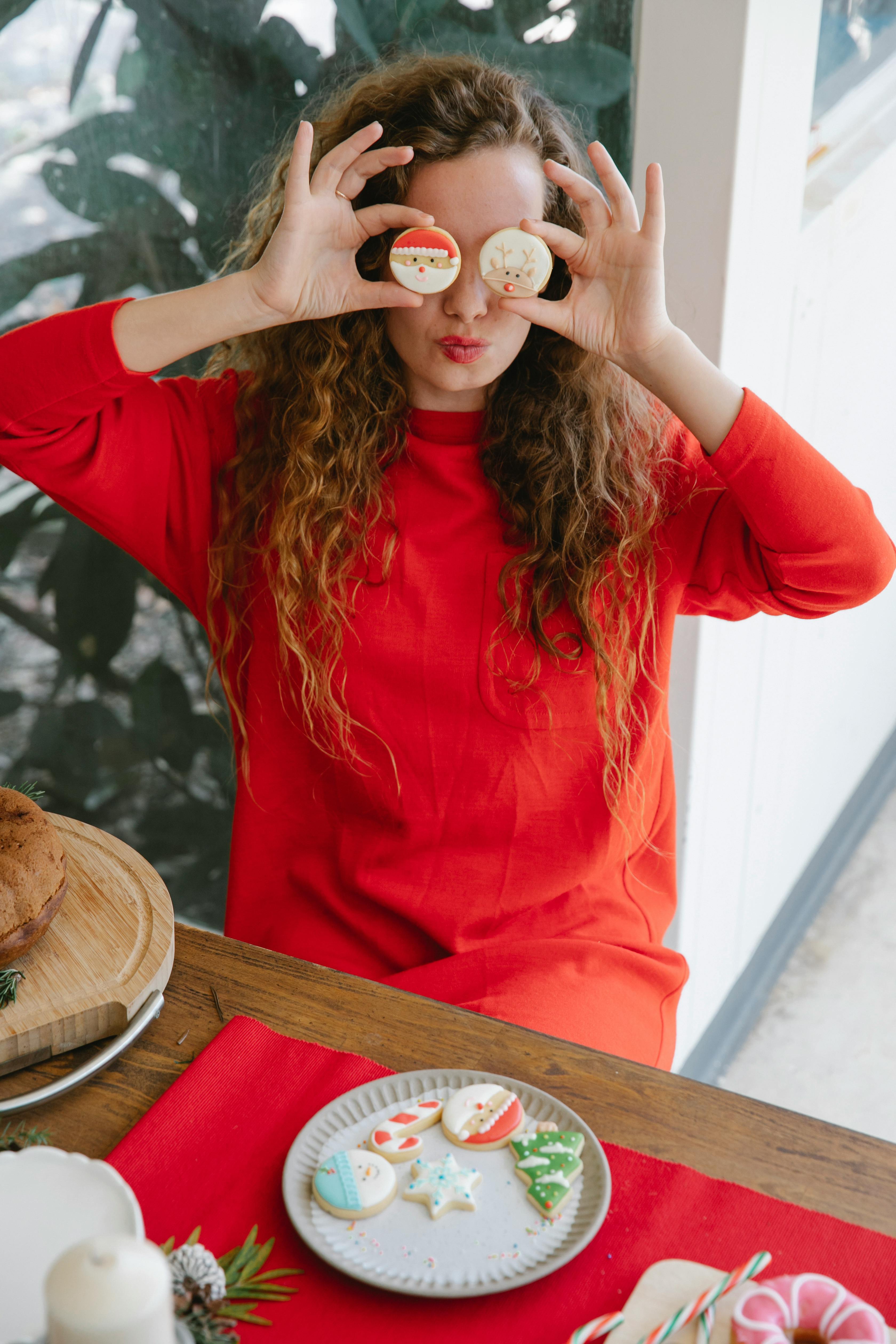 playful woman covering eyes with cookies