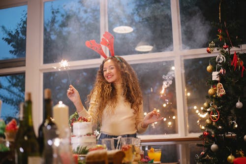 Happy woman celebrating Christmas with burning Bengal lights