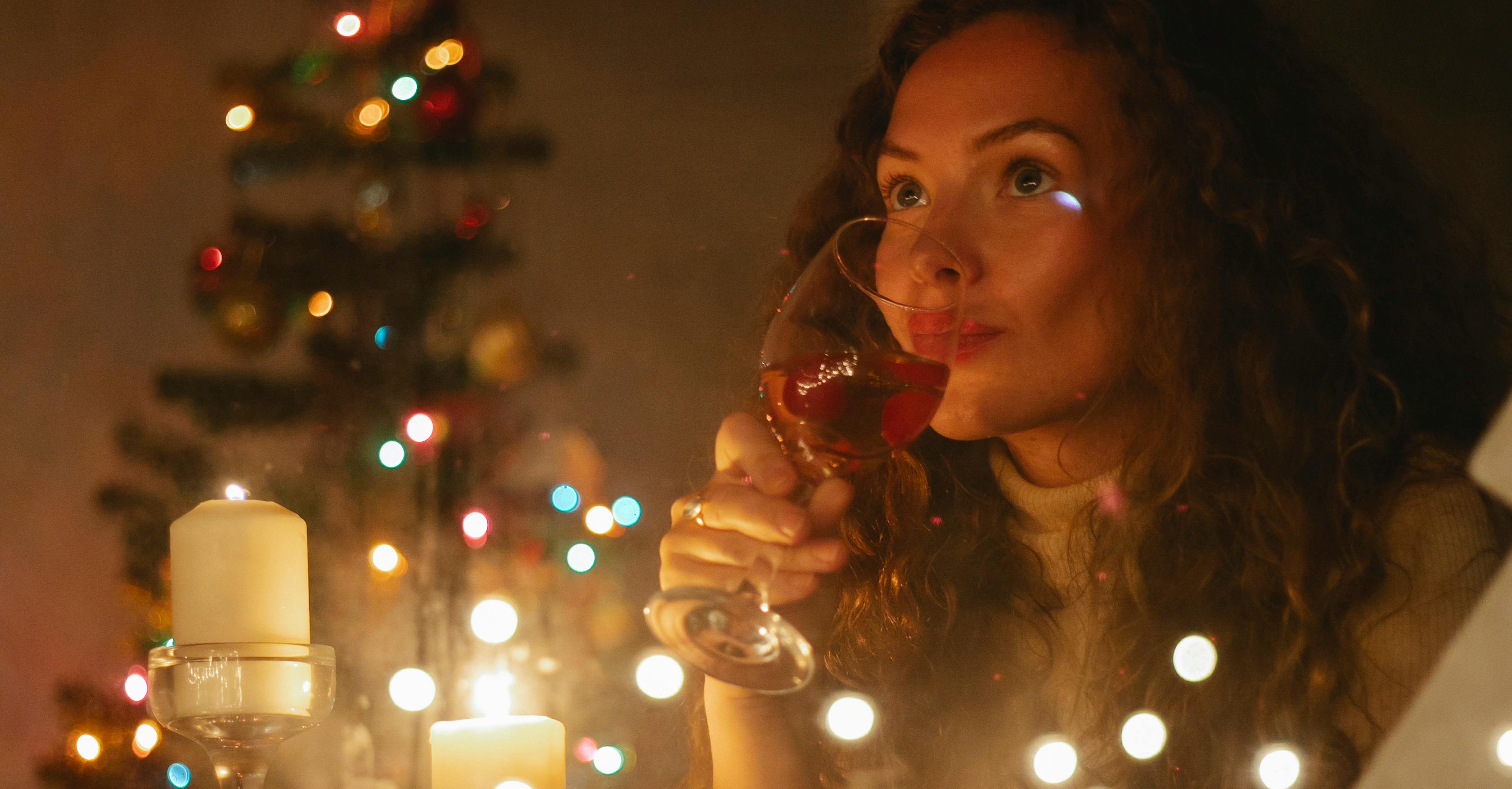 woman drinking champagne in room with christmas decorations