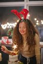 Cheerful woman enjoying Bengal light during Christmas celebration
