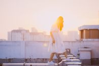 A Woman Walking on Rooftop Ducts