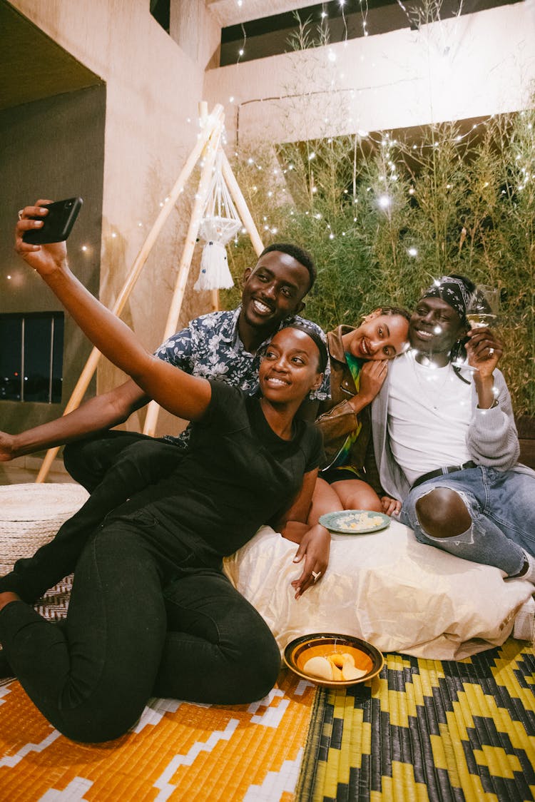 A Group Of Friends Sitting On Floor Making A Groupfie