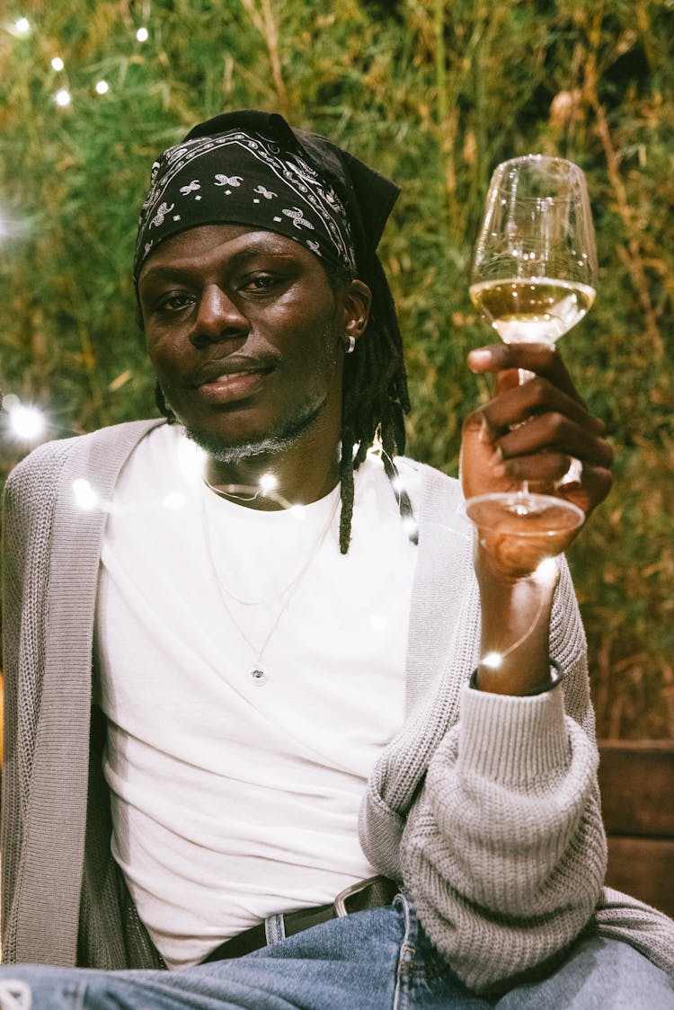 A Man In A Bandana Holding A Glass Of Wine