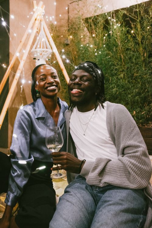 Free Happy African American couple enjoying a relaxing indoor party with cozy decorations. Stock Photo