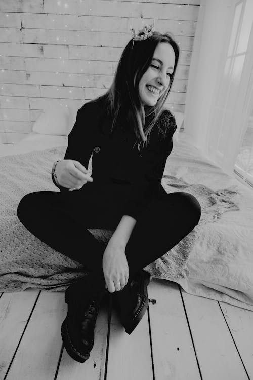 Cheerful woman sitting on floor in light room