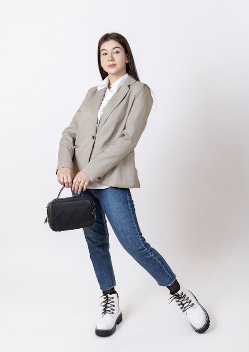 A Woman Posing in a Trendy Outfit while Holding a Bag