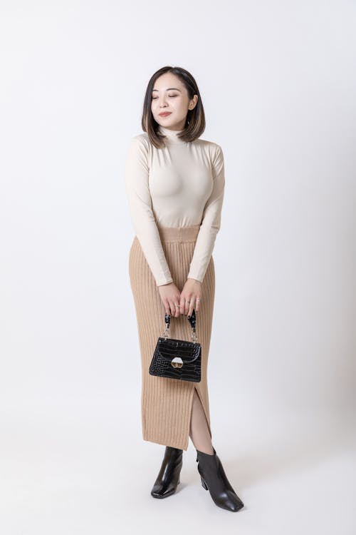 Free A Woman Posing in a Trendy Outfit while Holding a Bag Stock Photo