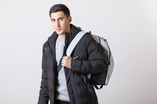 Man in Outerwear with Backpack Posing on White Background
