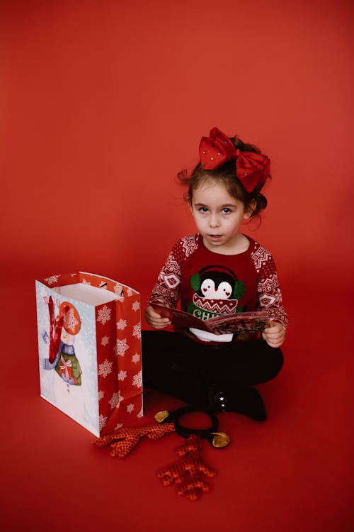 Girl Sitting on the Floor While Holding a Christmas Card
