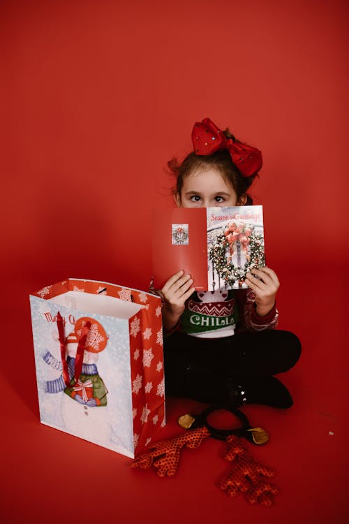 Cute Girl holding a Christmas Card 