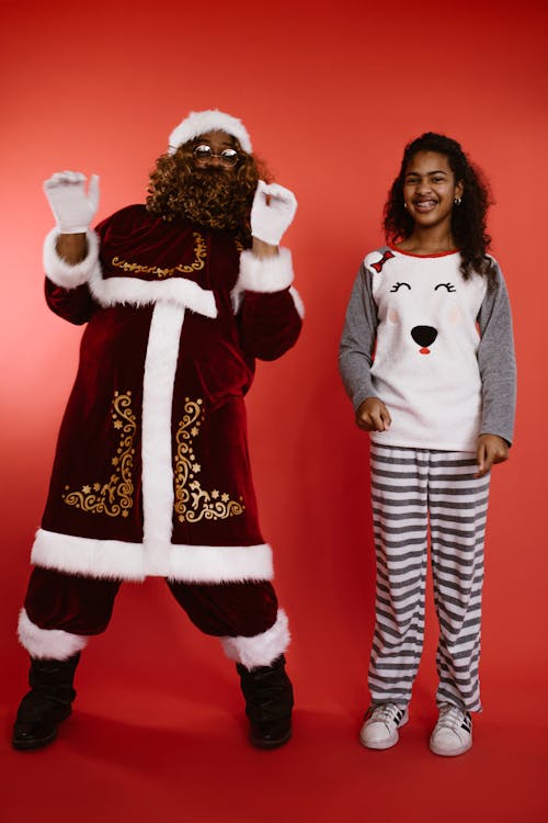 A Man in a Santa Costume and a Girl in her Pajamas