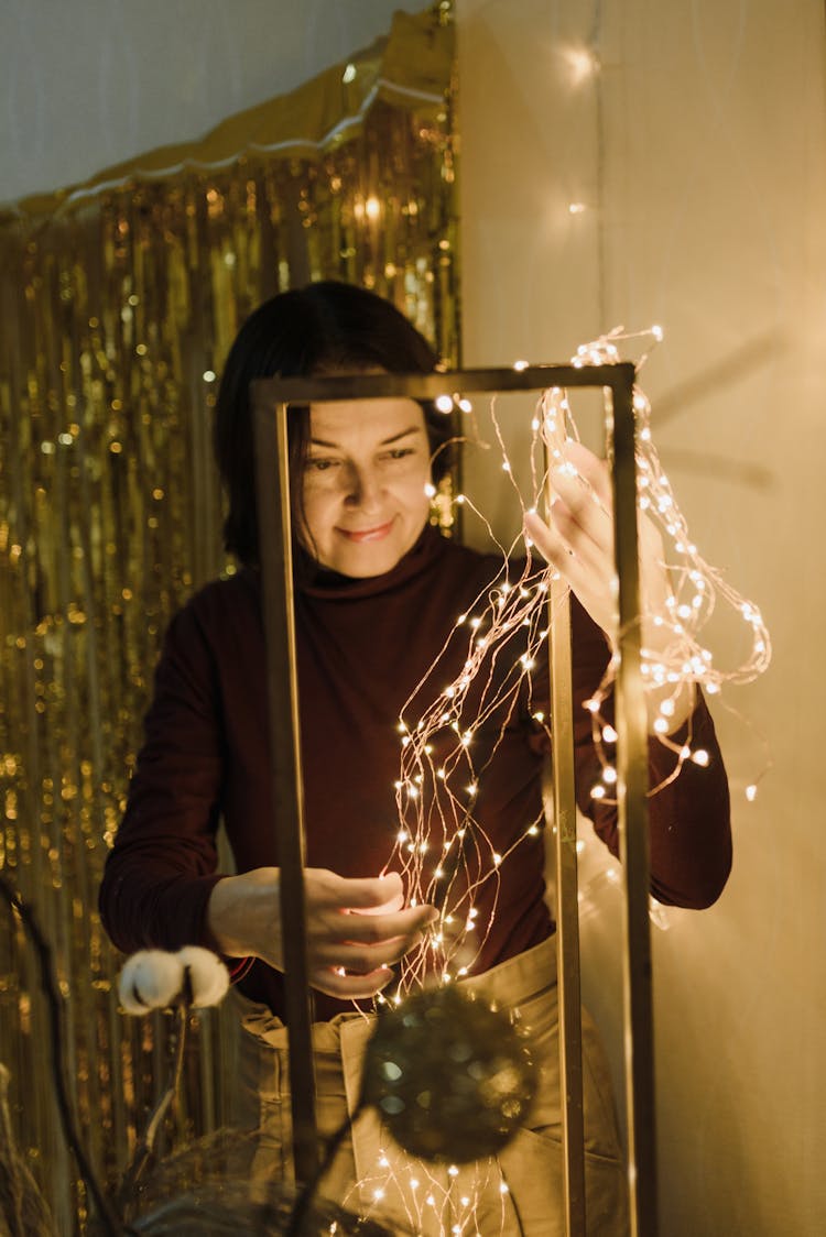 Woman Decorating Home With Lights